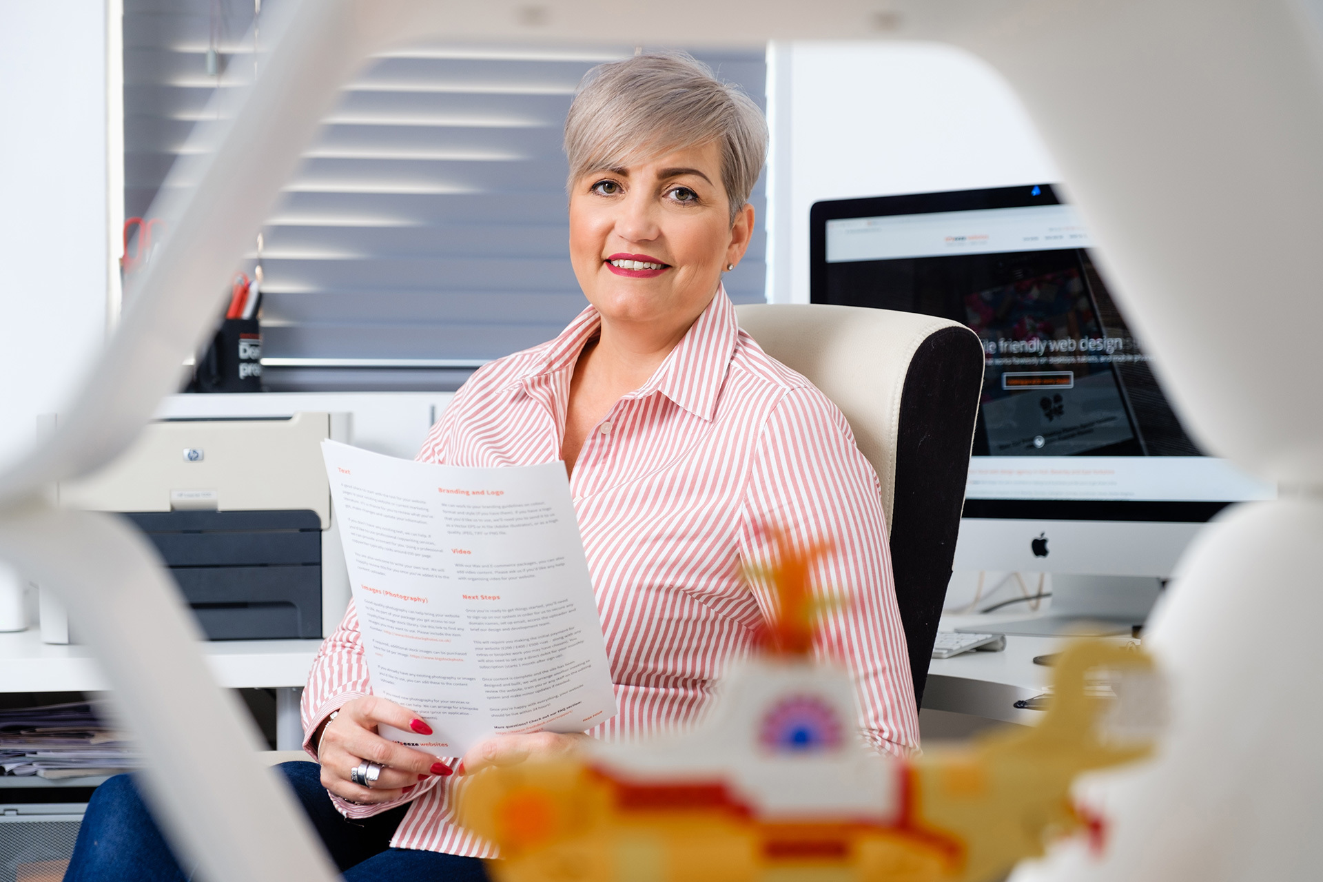 A woman holding a piece of paper while sitting at her office chair